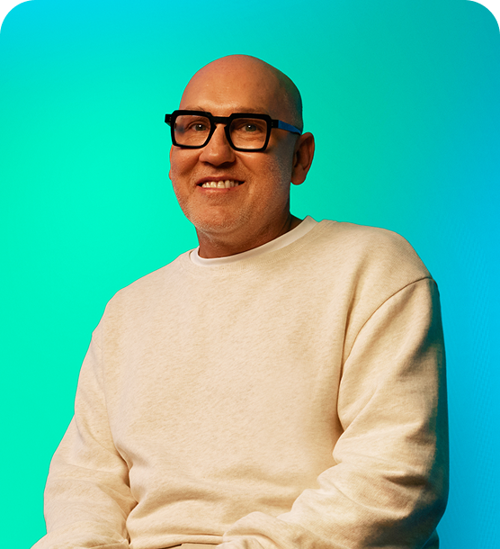 A man with glasses sitting and smiling