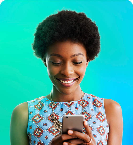 A woman smiling while looking at her phone